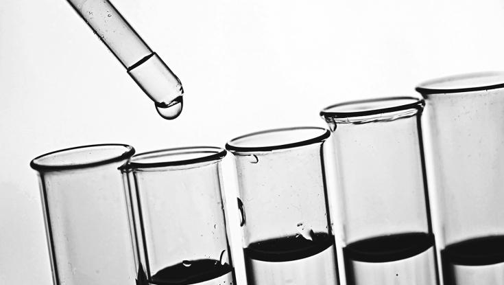 a line of beakers with a dropper