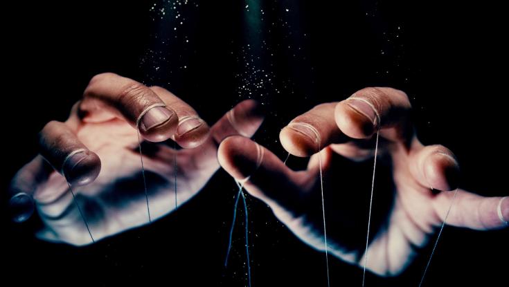 A picture of hands moving strings like a puppet