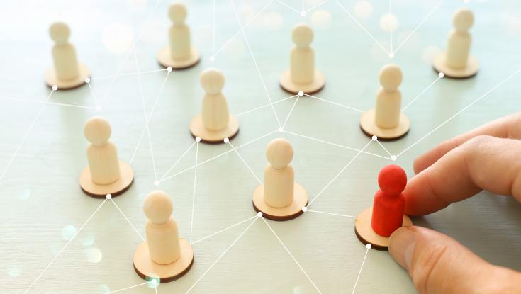 A red chess piece standing out from rest leading change and connecting others