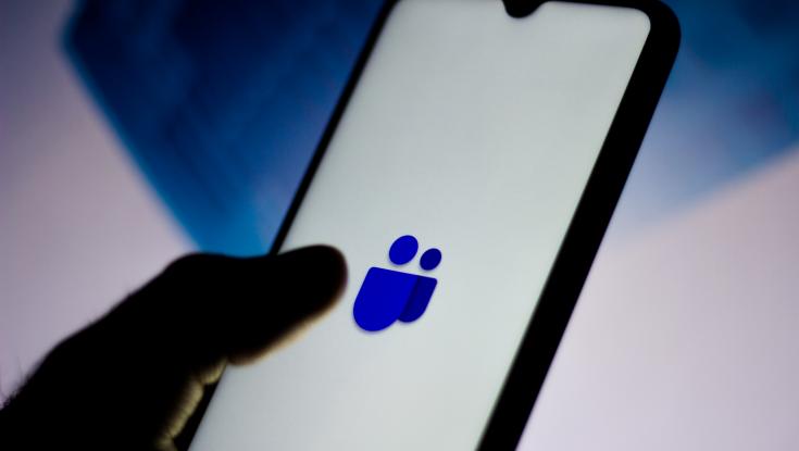 A picture of someone holding a phone with a Microsoft Teams Logo