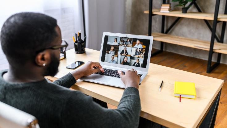 A man sitting at a desk having a virtual meeting