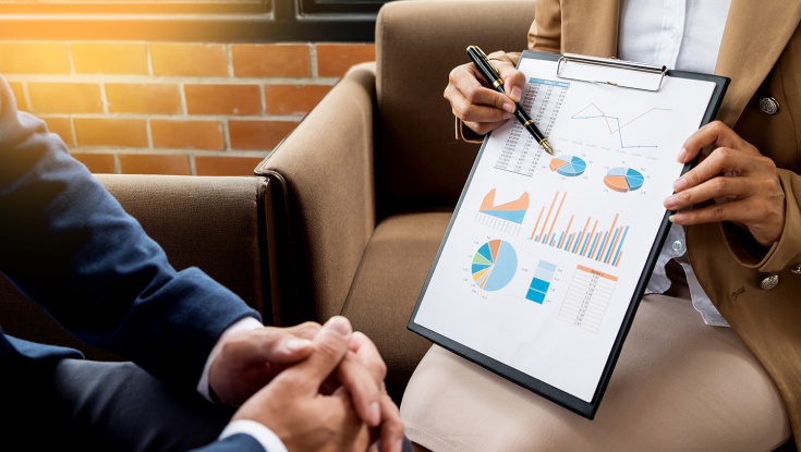 Image of a person showing a document with charts and graphs