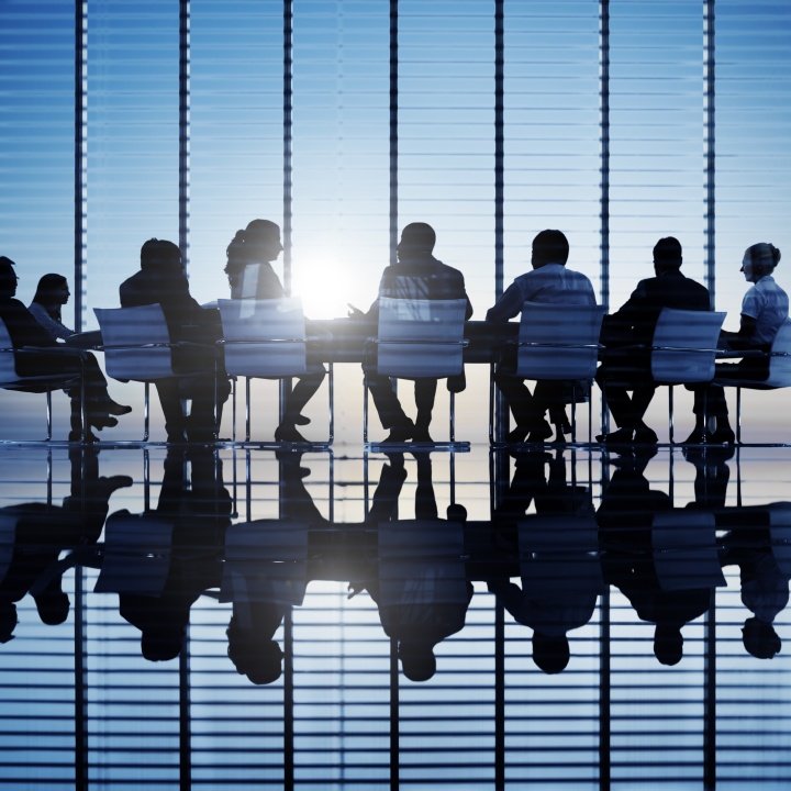 A bunch of people sitting around a conference room
