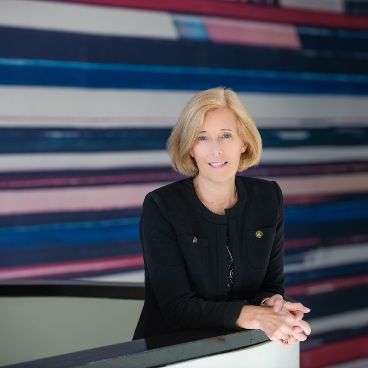 A picture of Cindy Anderson in the APQC Lobby at the top of the stairs