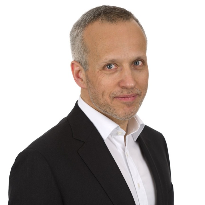 A photo of a male named Francis Hintermann in a black blazer and white shirt on a white background.