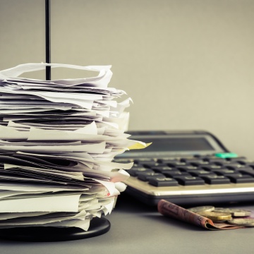 Calculator next to a stack of paper receipts