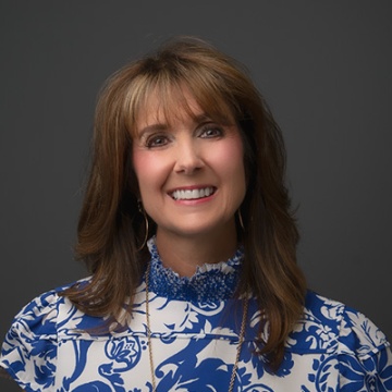 A photo of Cindy Hubert in a blue and white dress in APQC office