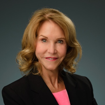 A picture of Carla O'Dell in a black suit with a gray brackground