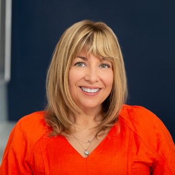 A picture of a lady named Cathy Hill in an orange dress on a blue background.