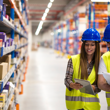Man and woman looking at tablet in a warehouse
