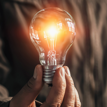 Man holding a glowing lightbulb