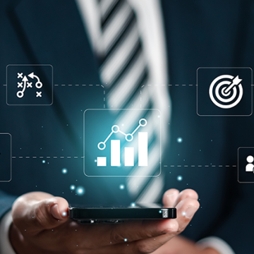 Man in a suit holding a cell phone with floating icons