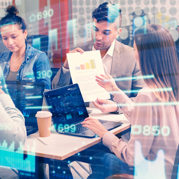 Employees working with data around a conference table