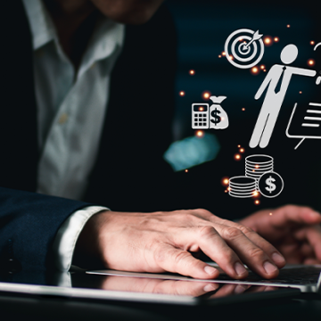 Man typing on a computer with data icons